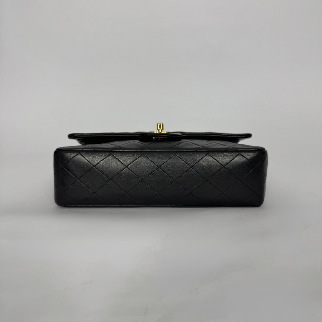 Black quilted handbag on a light gray background