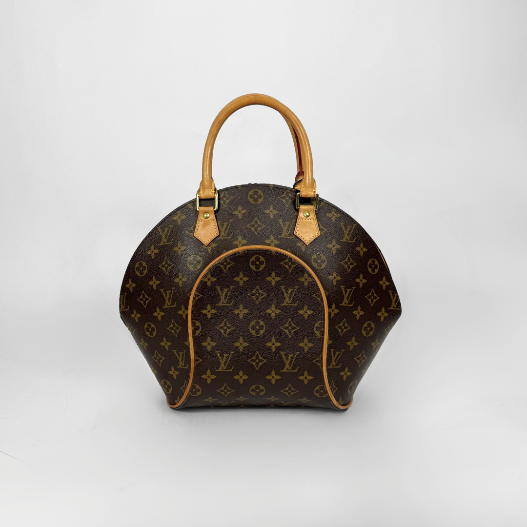 Brown handbag with gold accents held by a gloved hand on a white background