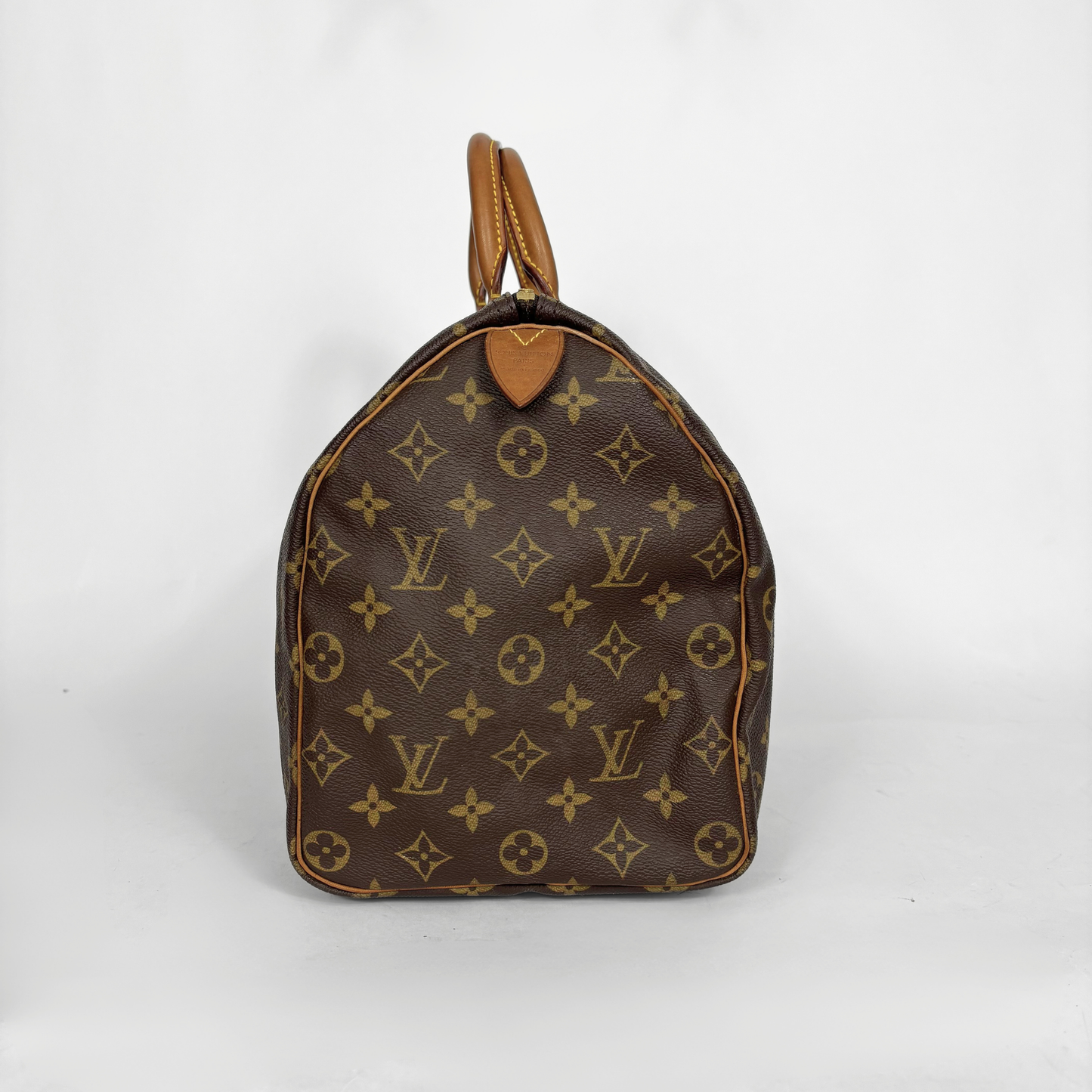 Bolso marrón con estampado de monograma sobre fondo blanco.