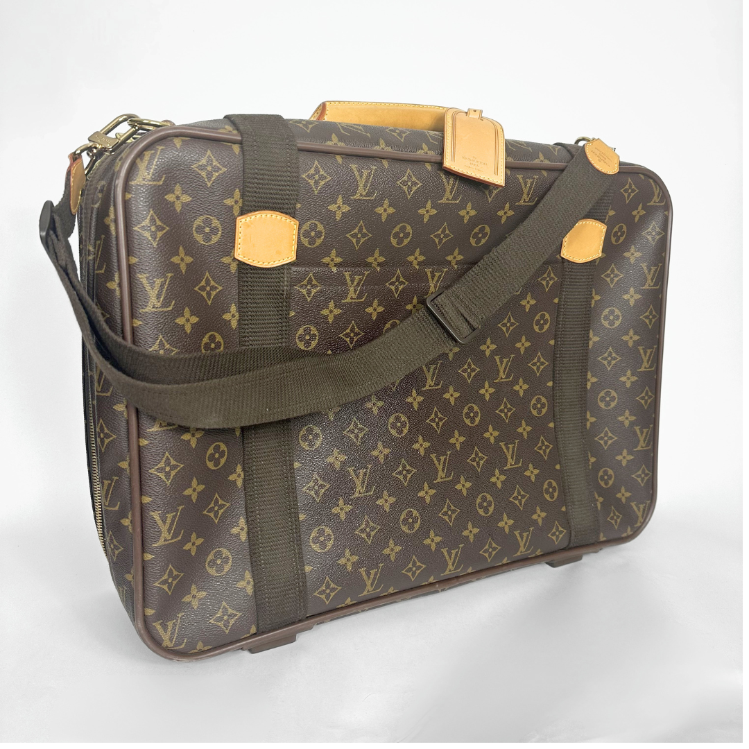 Brown suitcase with gold accents and monogram pattern on a white background