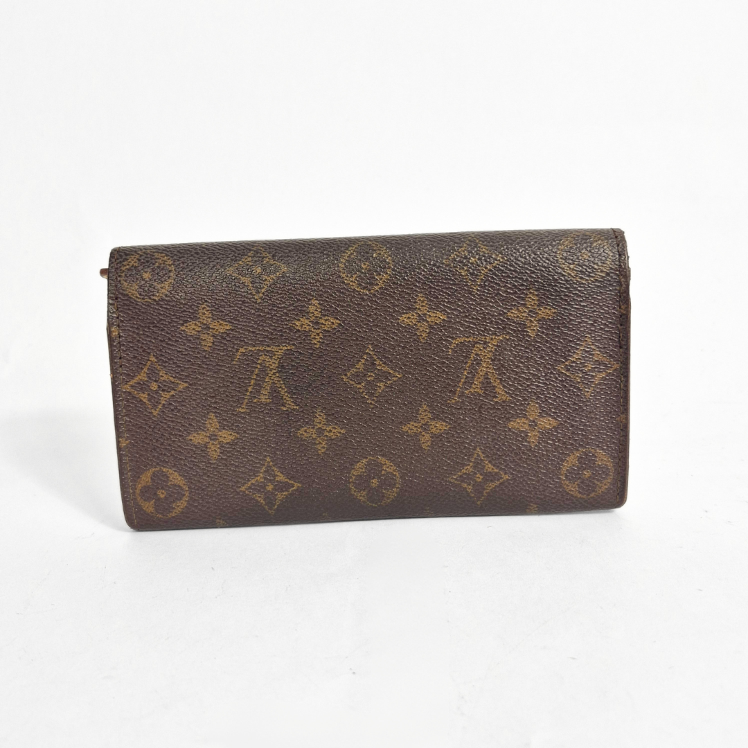 Brown wallet with monogram pattern on a white background