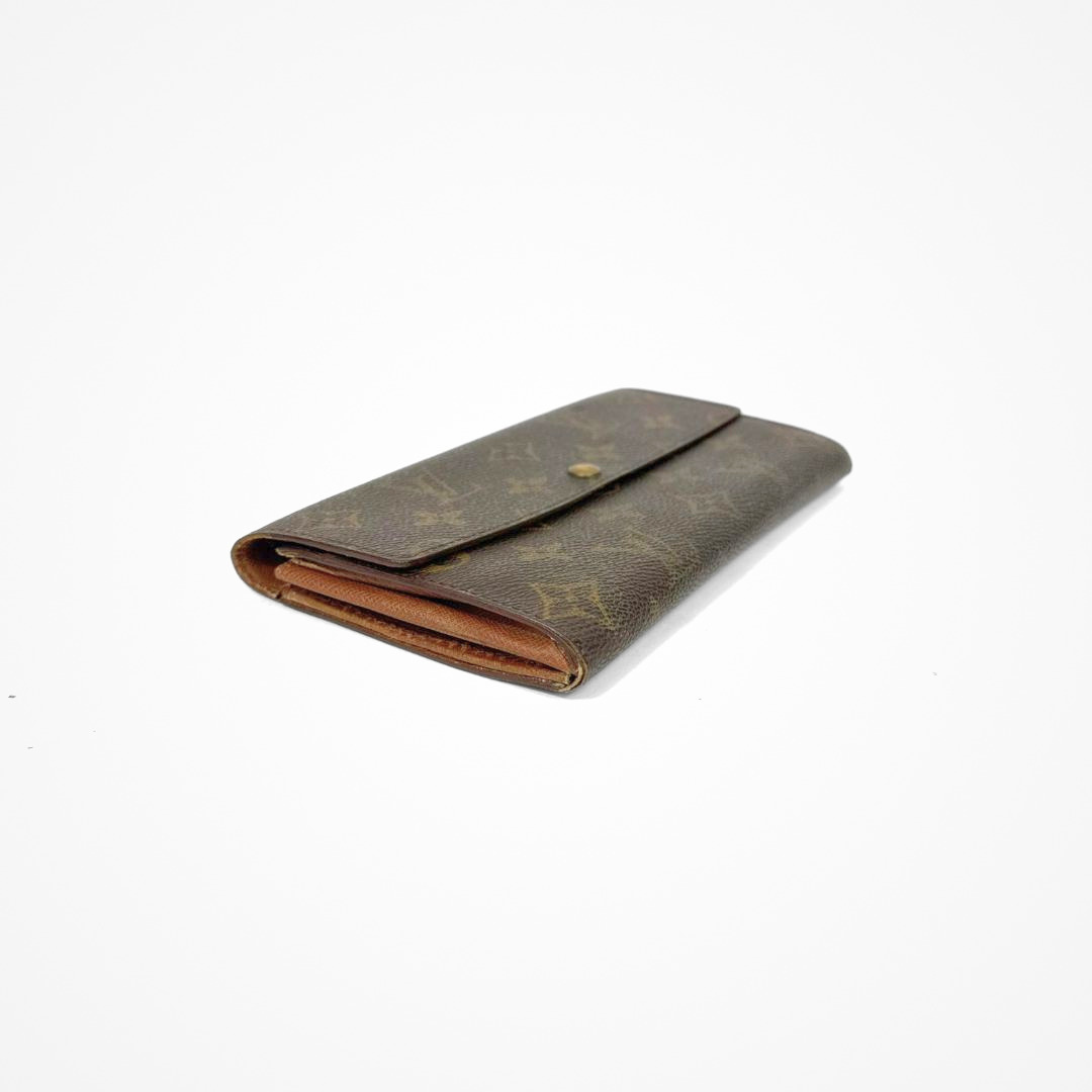 Louis Vuitton Wallet Large with gold monogram pattern on a white background