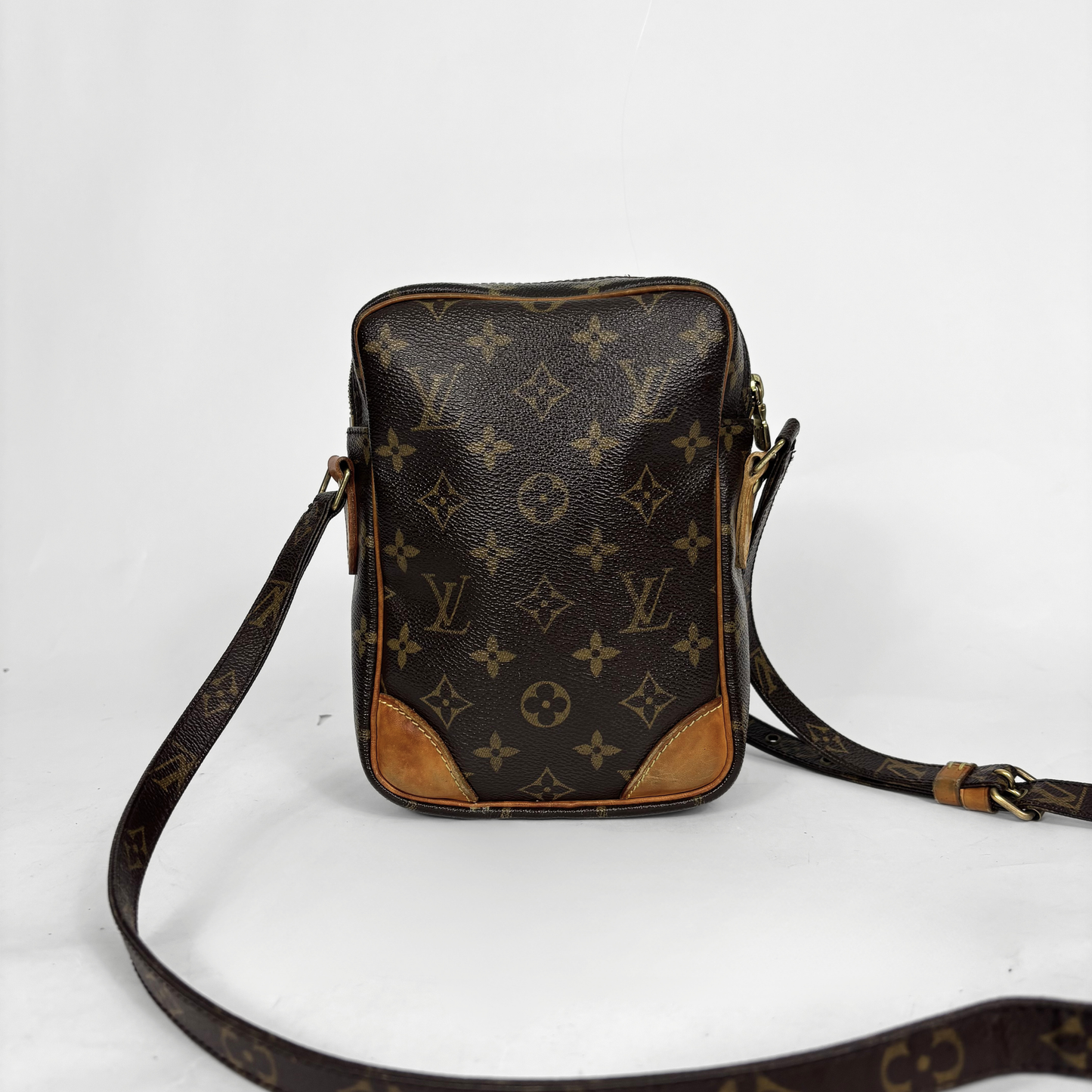 Brown leather bag with monogram pattern on a white background