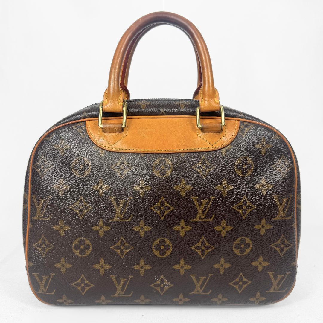 A Louis Vuitton monogram canvas dome handbag with tan leather handles and trim, shown against a plain white background.