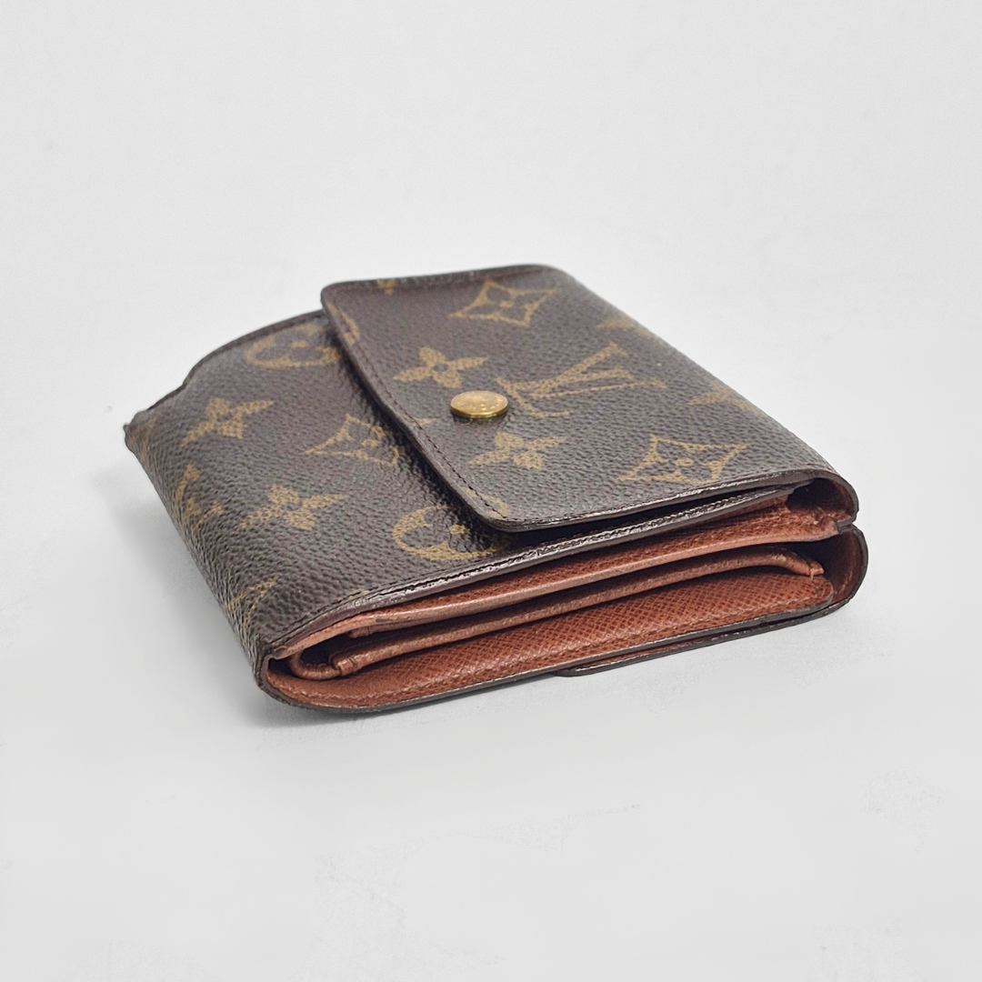 Louis Vuitton wallet with monogram pattern on a light gray background
