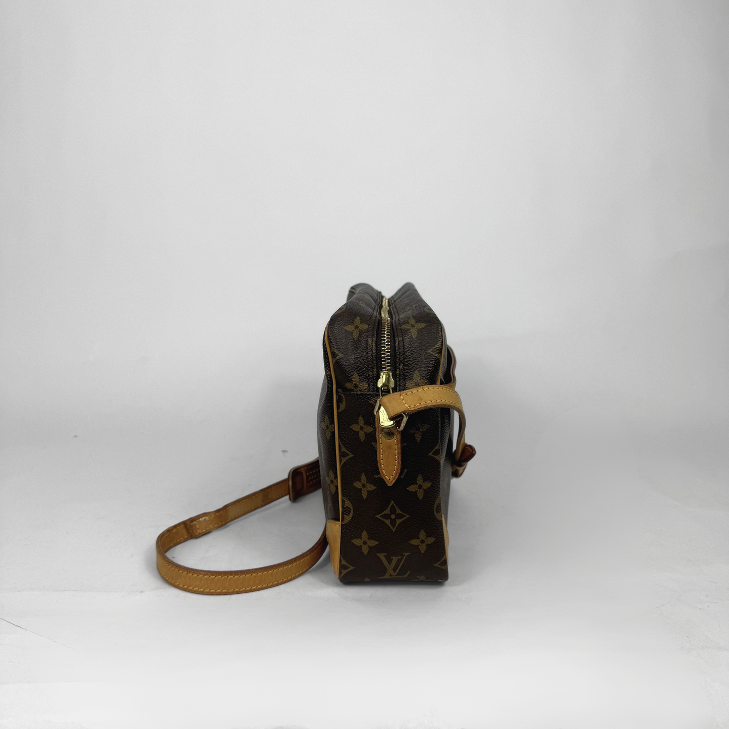 Brown leather handbag with gold accents on a white background