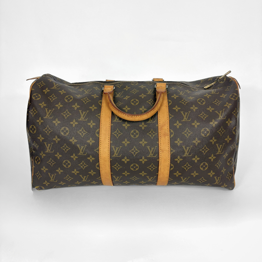 Louis Vuitton monogram travel bag with brown leather straps on a white background
