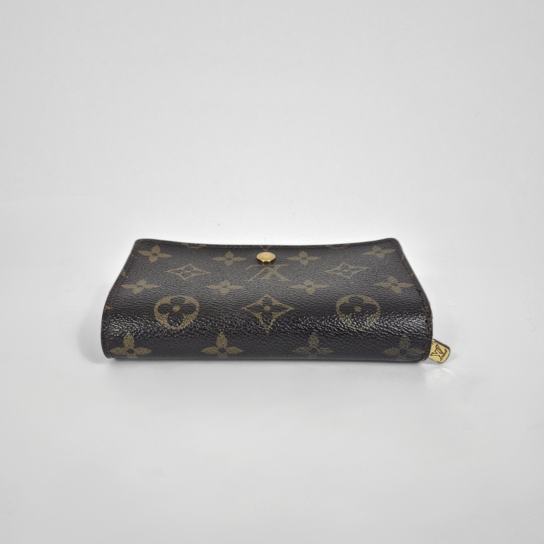 Designer handbag with monogram pattern on a light gray background