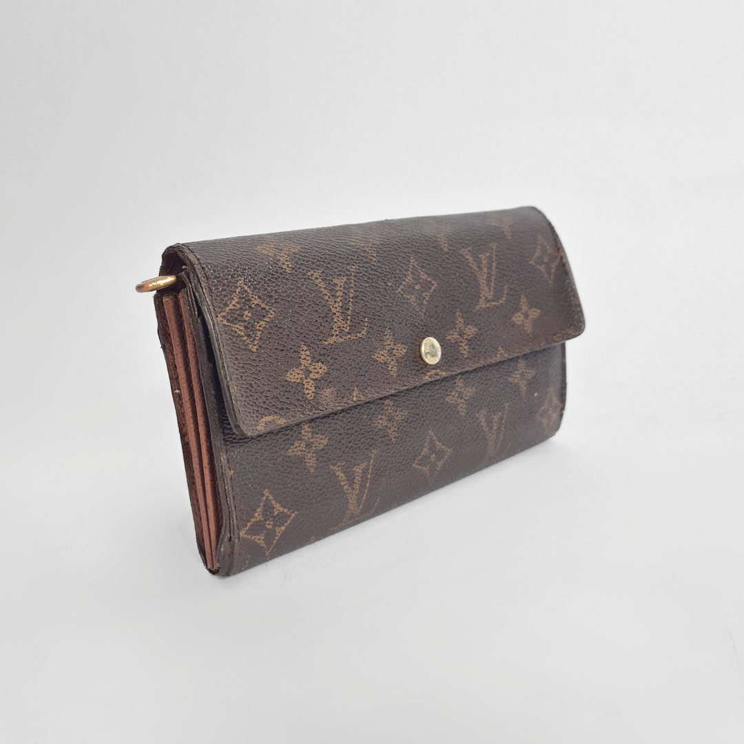 Brown wallet with monogram pattern on a light gray background