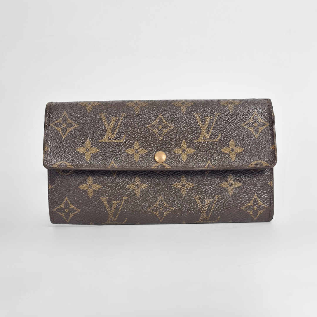 Louis Vuitton wallet with monogram pattern on a light gray background