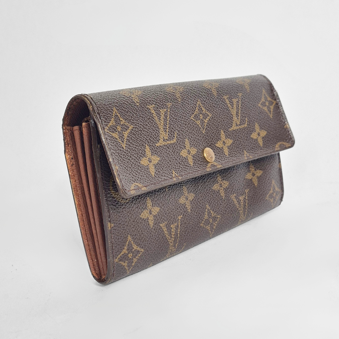 Louis Vuitton wallet with monogram pattern on a light gray background