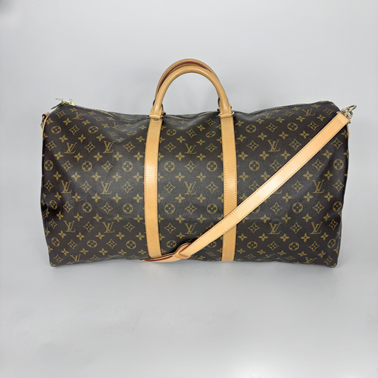 Designer travel bag with monogram pattern on a gray background