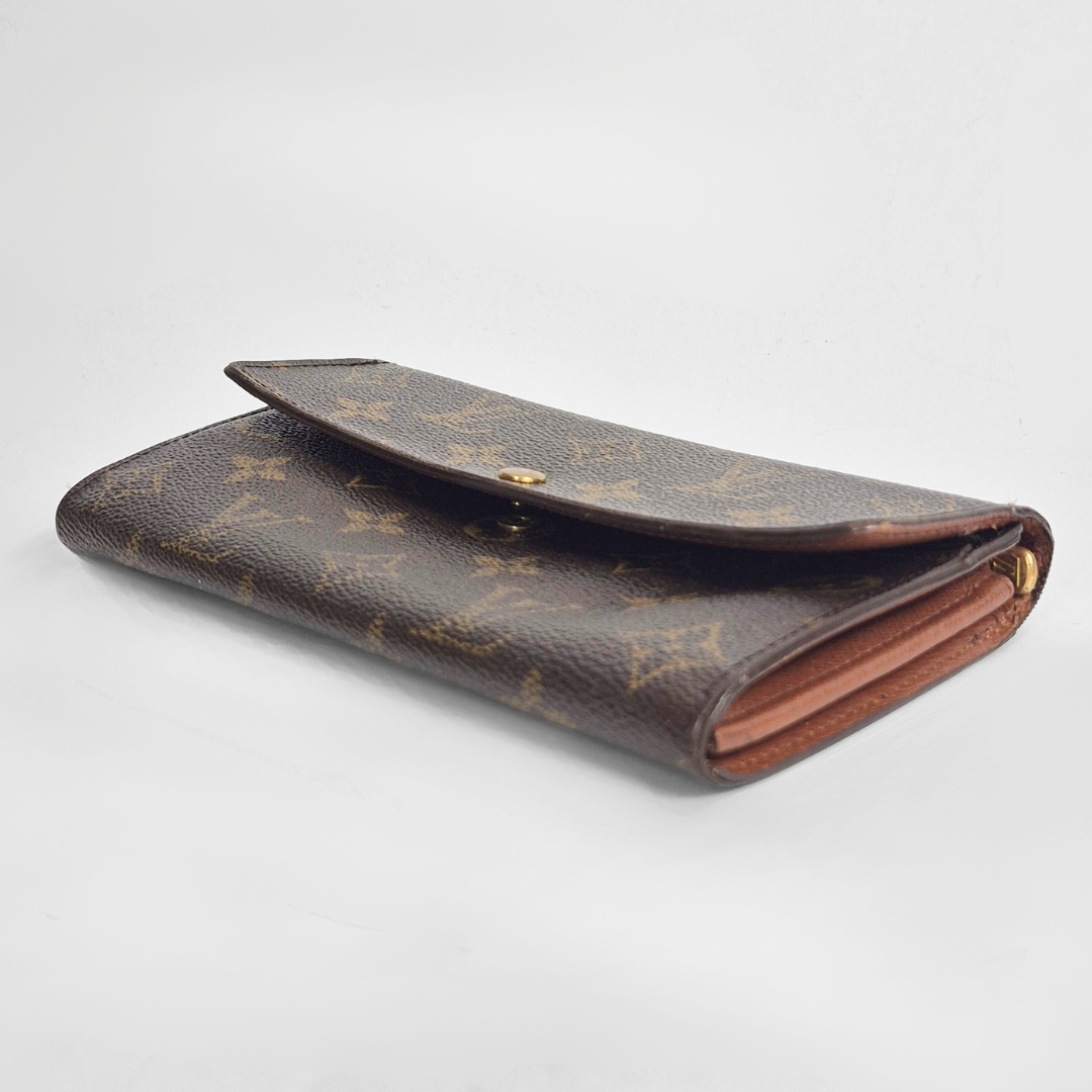 Brown wallet with monogram pattern on a light gray background