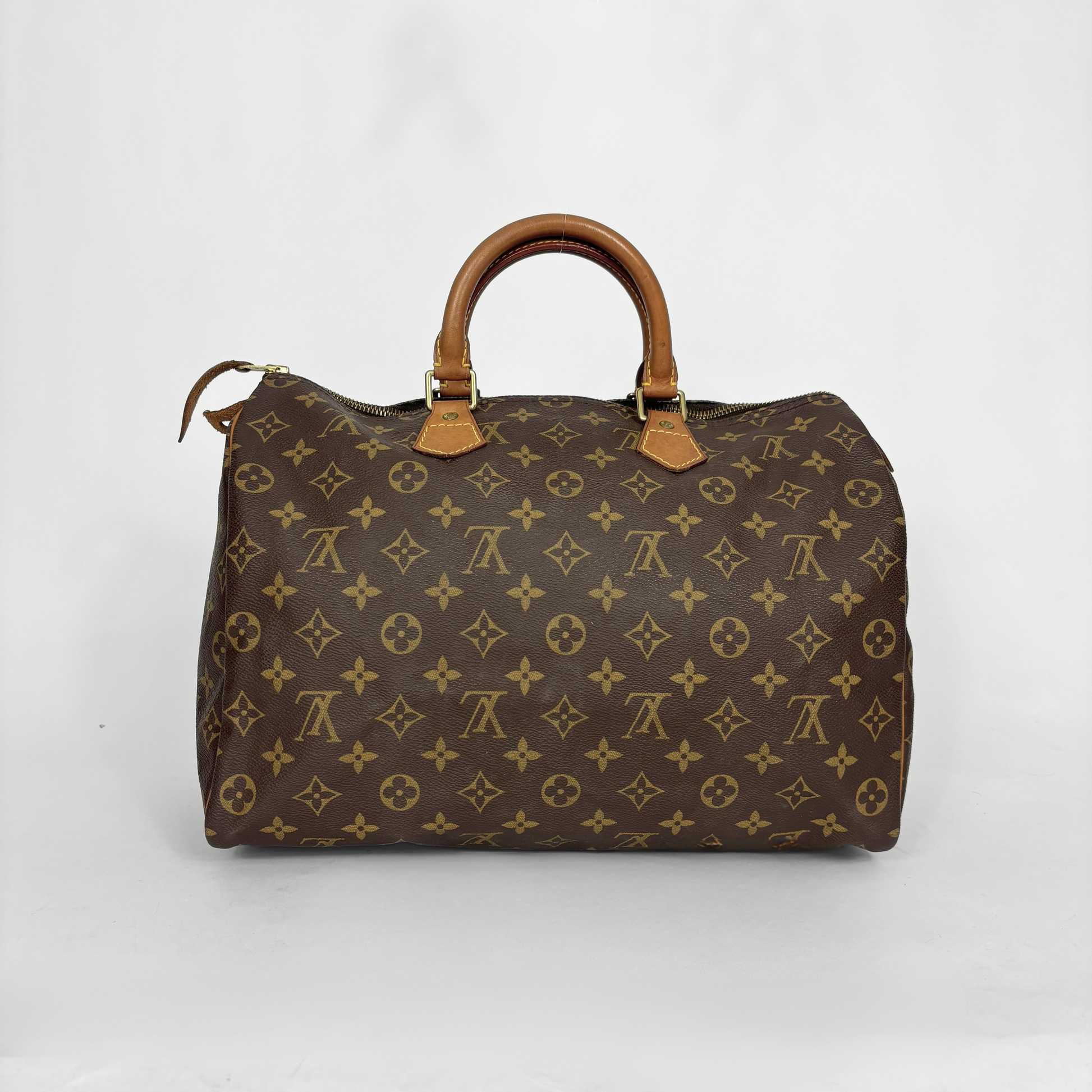 Bolso marrón con estampado de monograma sobre fondo blanco.