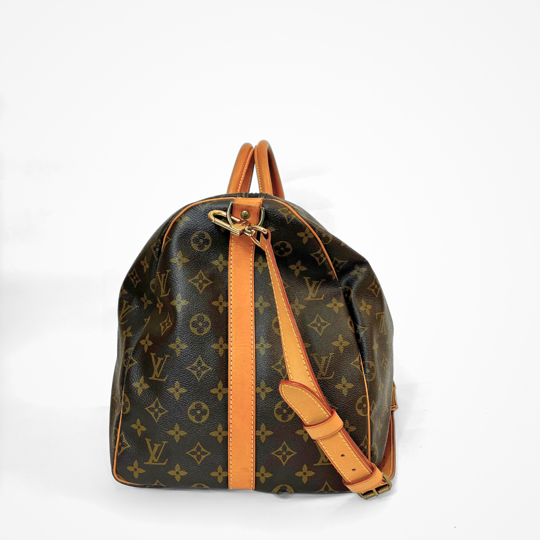 Brown LV duffel bag with monogram canvas and tan leather straps on a white background