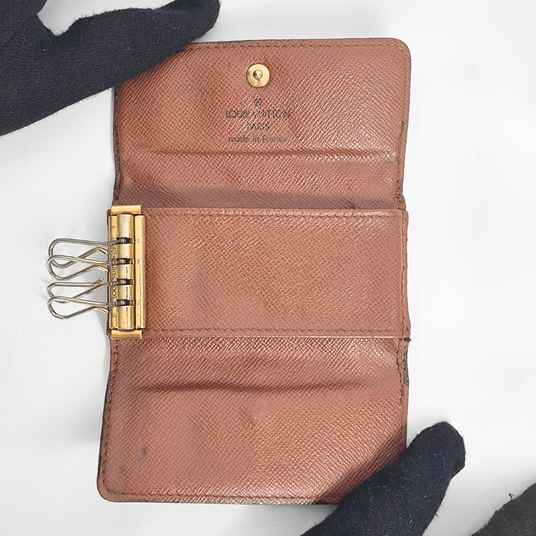 Brown leather wallet with gold clasp on a white background