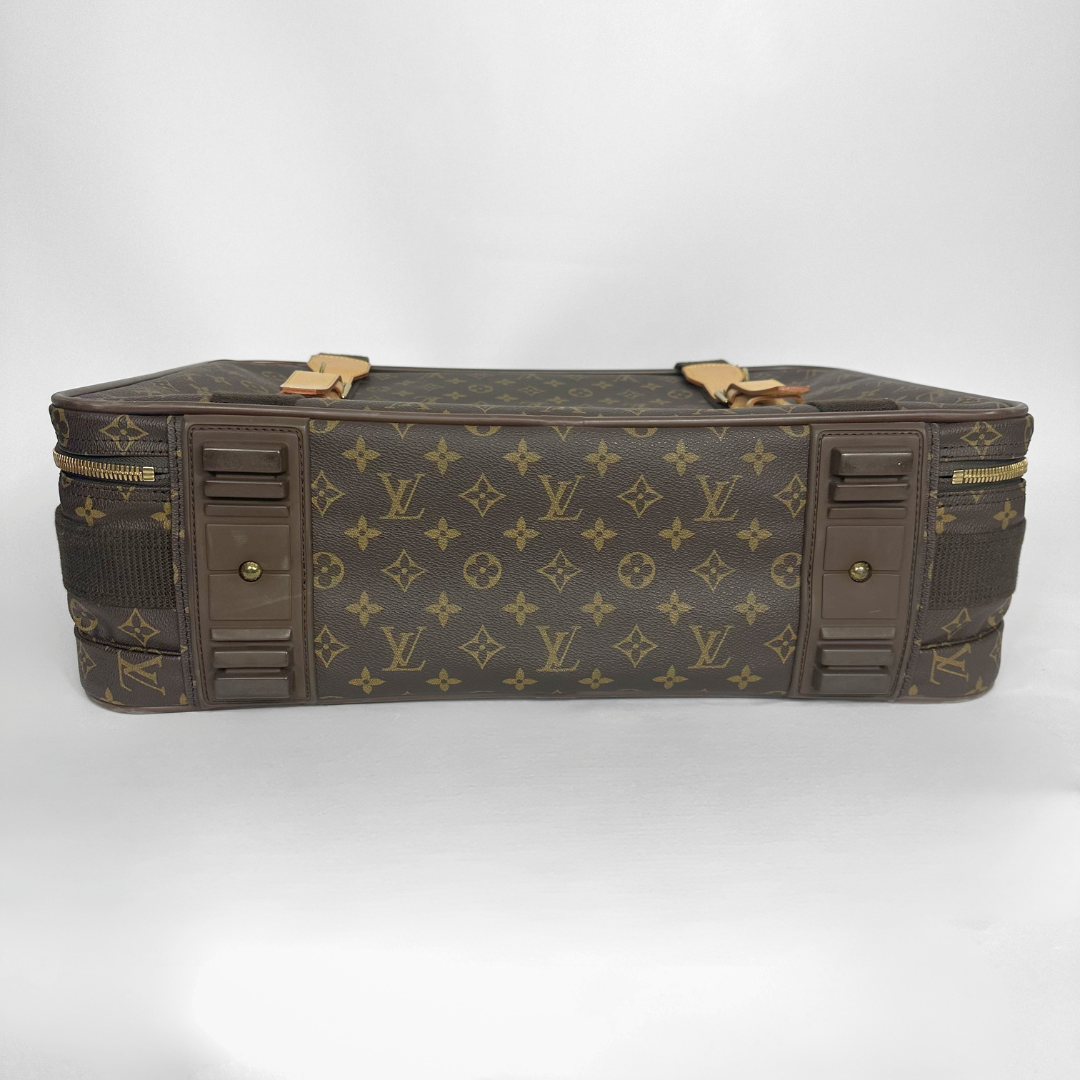 Brown suitcase with gold accents and monogram pattern on a white background
