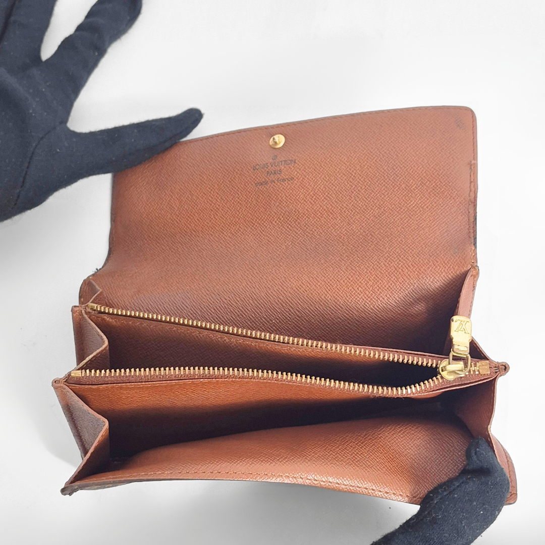 Brown leather wallet with gold zipper on a white background