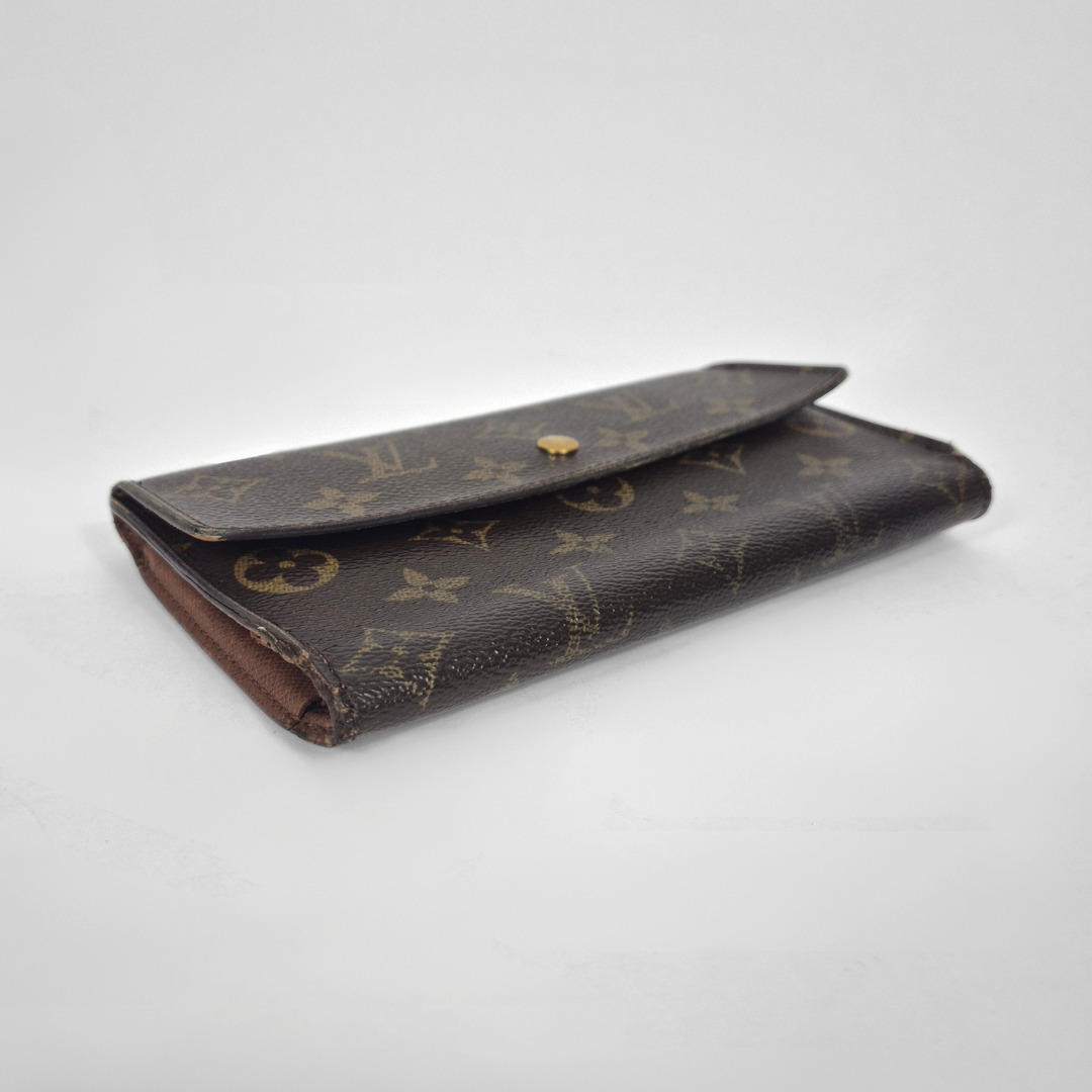 Designer wallet with monogram pattern on a light gray background