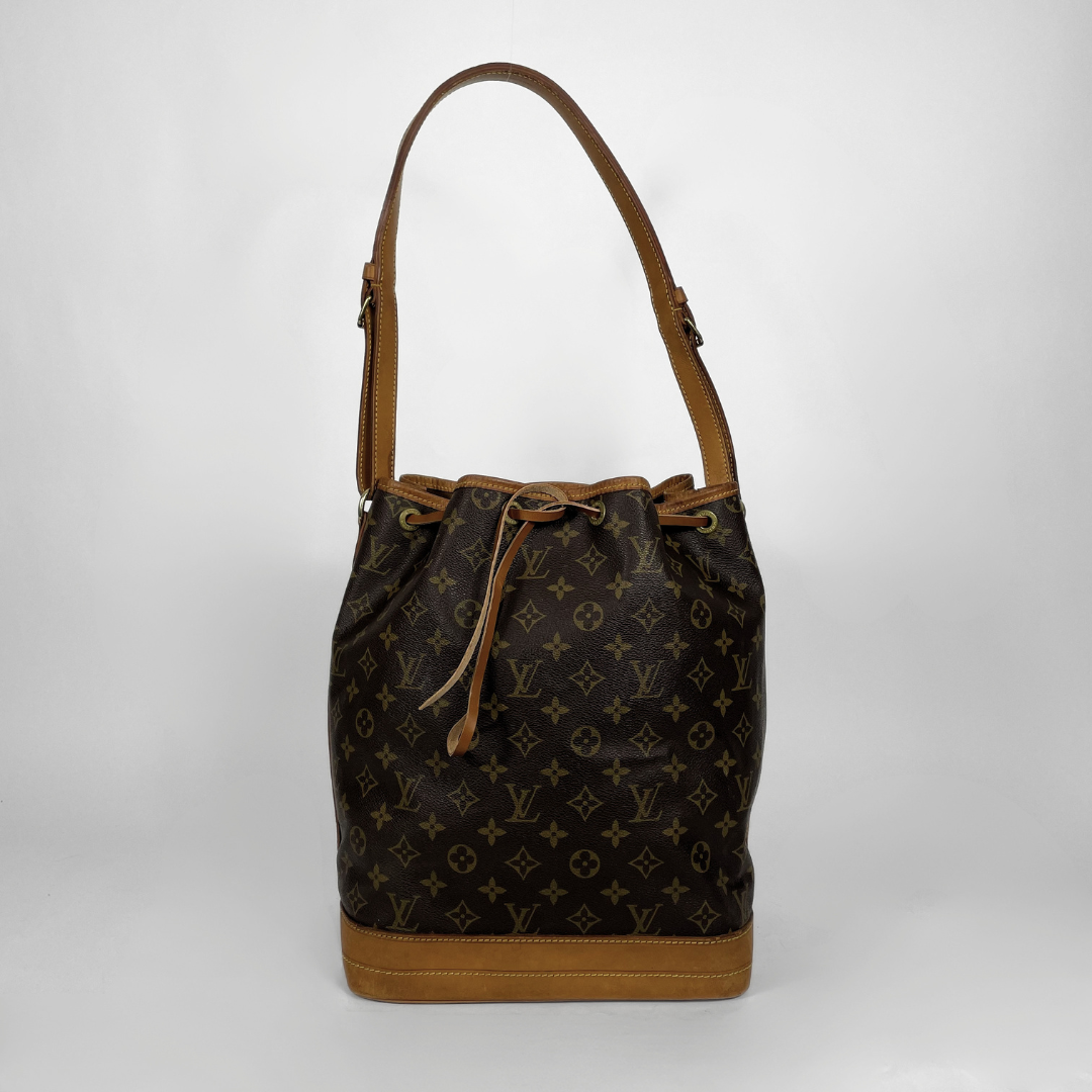 Louis Vuitton monogram canvas bucket bag with tan leather trim, drawstring closure, and shoulder strap, photographed against a light gray studio background.
