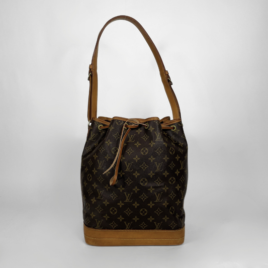 Louis Vuitton monogram canvas bucket bag with tan leather trim, drawstring closure, and shoulder strap, photographed against a light gray studio background.