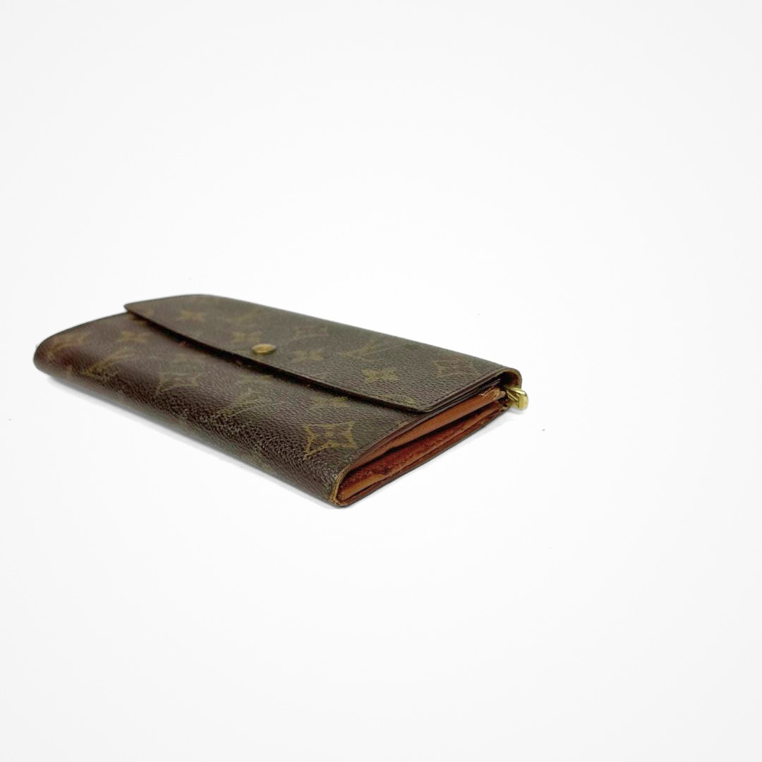 Louis Vuitton Wallet Large with gold monogram pattern on a white background