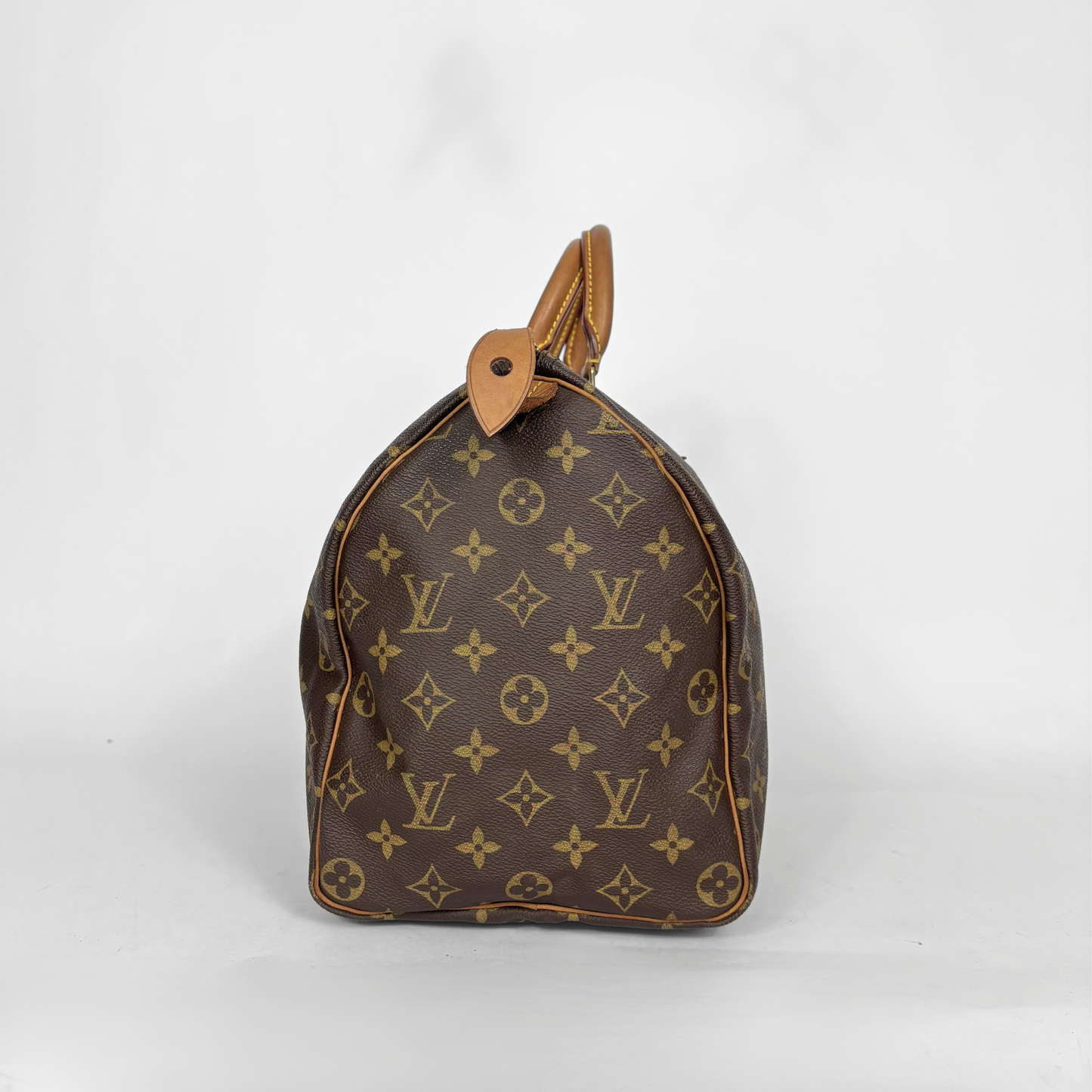 Bolso marrón con estampado de monograma sobre fondo blanco.