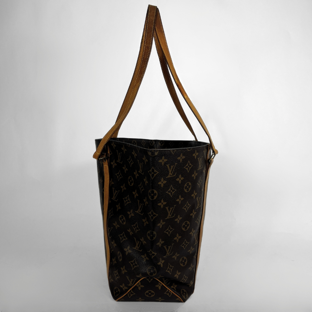 A Louis Vuitton monogram tote bag in dark brown coated canvas with tan leather shoulder straps, shown against a plain light gray background.