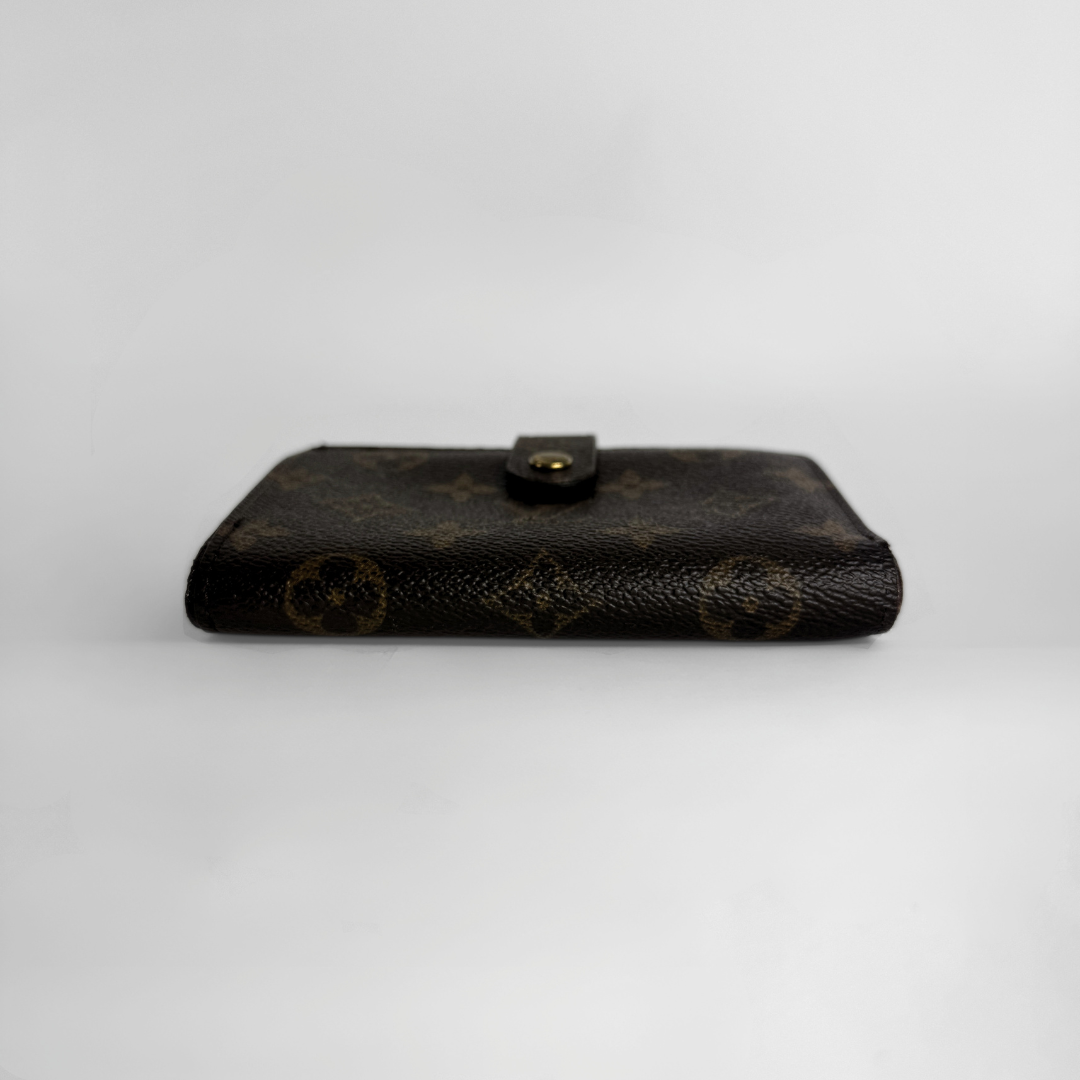 A dark brown Louis Vuitton monogram wallet with a snap-button closure, photographed against a neutral light gray background.