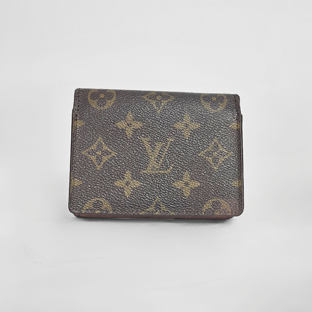 Louis Vuitton wallet with monogram pattern on a light gray background