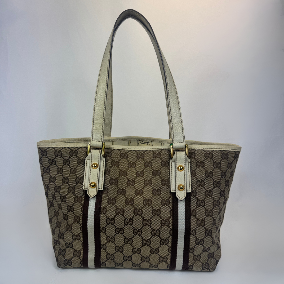 A vintage Gucci GG Supreme tote bag in brown and beige canvas with cream-colored leather handles and trim, featuring gold-tone hardware.