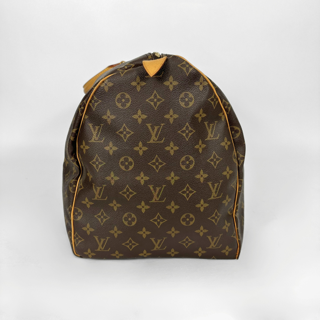 Louis Vuitton monogram duffel bag with tan handles on a white background