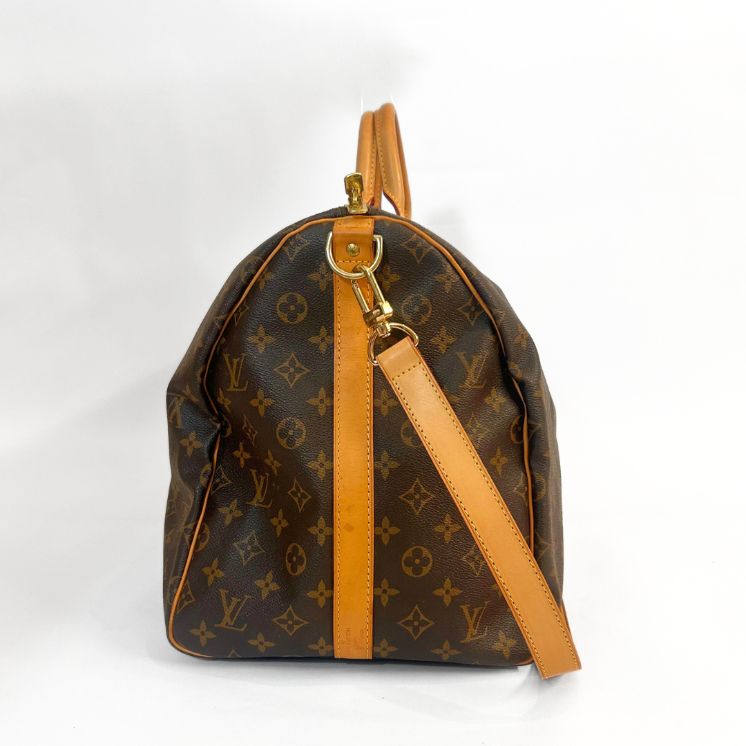 Designerhandtasche mit Monogrammmuster auf weißem Hintergrund