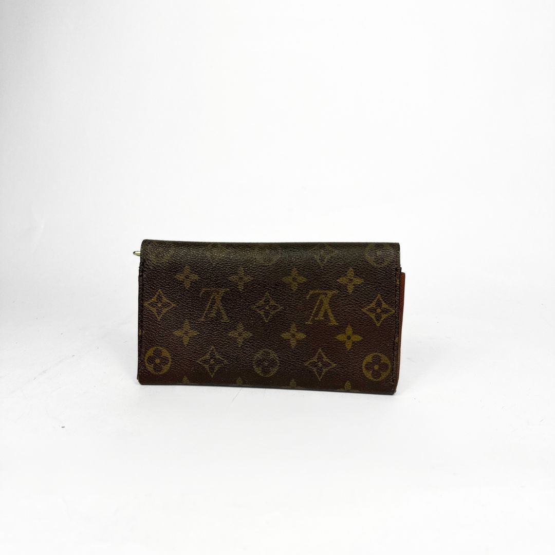 Louis Vuitton wallet with monogram pattern on a white background