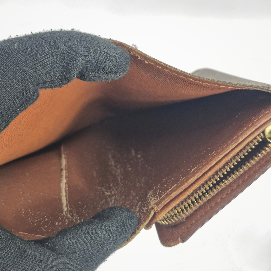 Brown leather wallet with a zipper on a white background