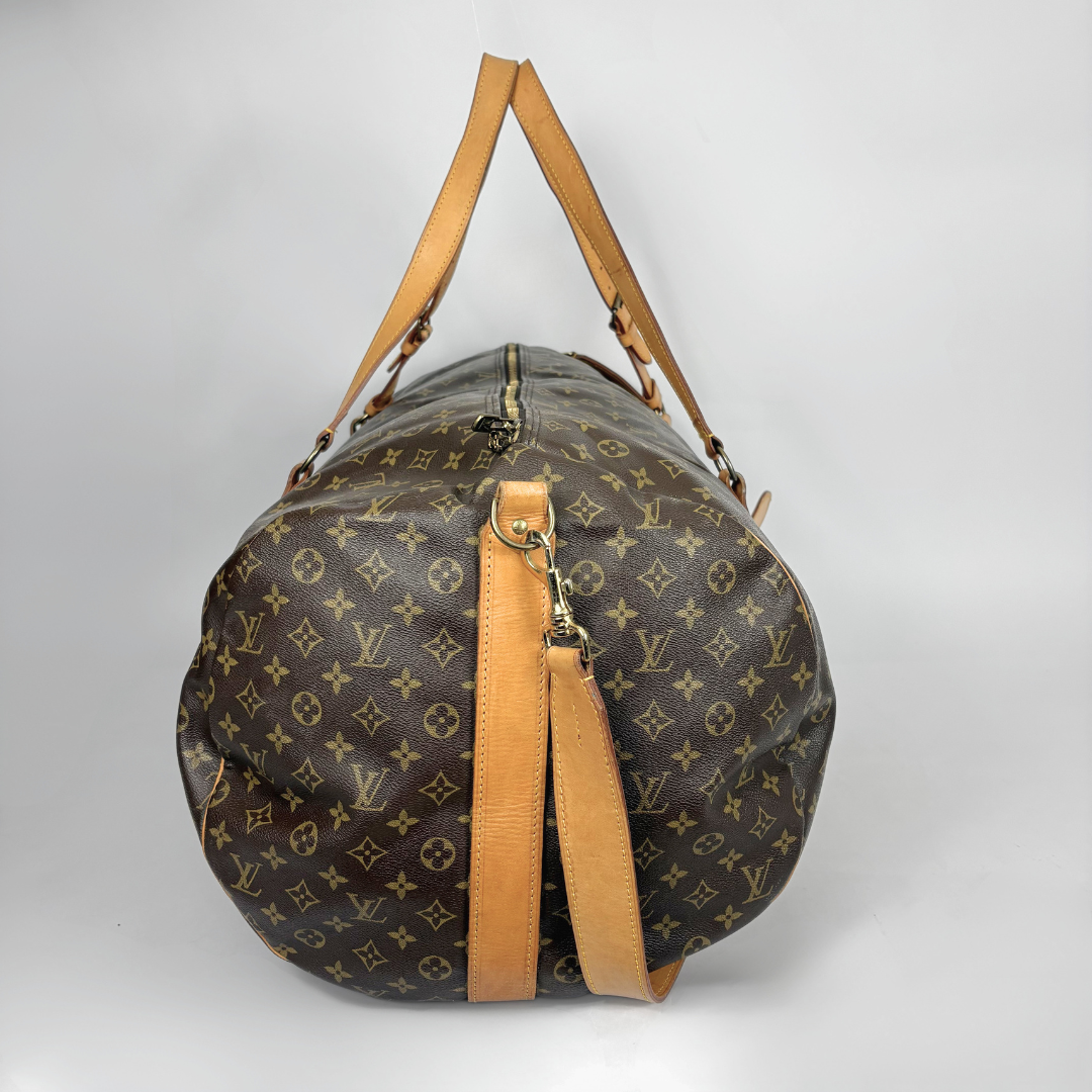 Louis Vuitton duffel bag with monogram pattern on a light gray background