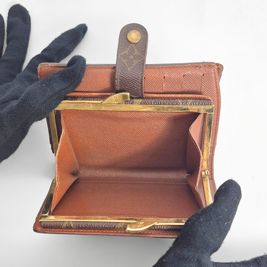 Braune Ledergeldbörse mit goldenen Akzenten, offen gehalten 