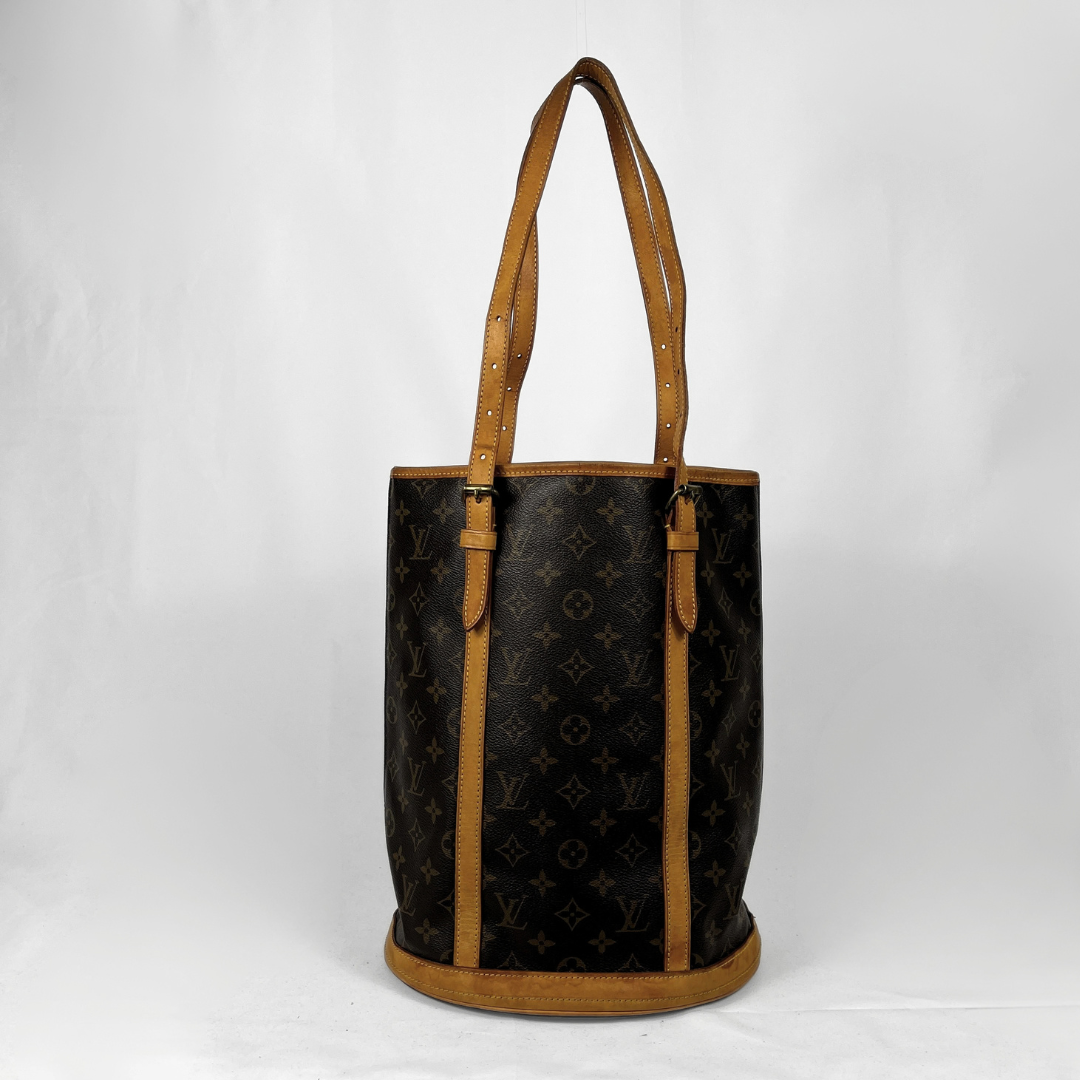 A Louis Vuitton monogram canvas tote bag with tan leather trim and shoulder straps, photographed against a plain white background.