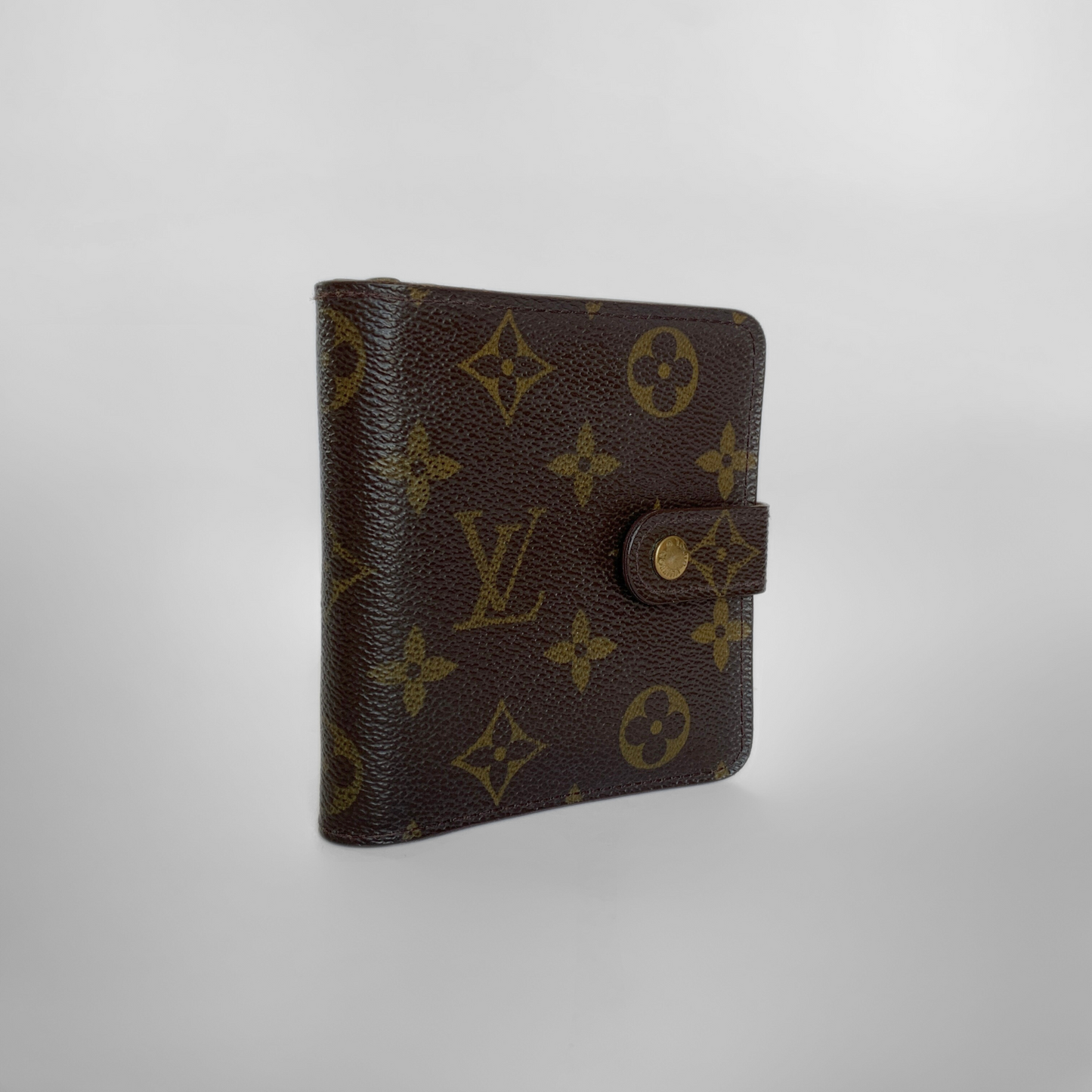 Brown wallet with gold monogram pattern on a light gray background