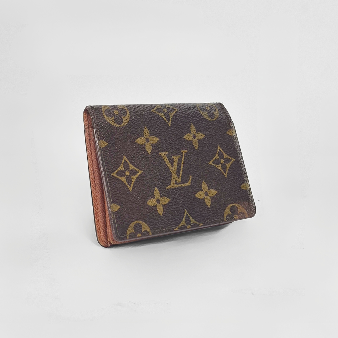 Louis Vuitton wallet with monogram pattern on a light gray background