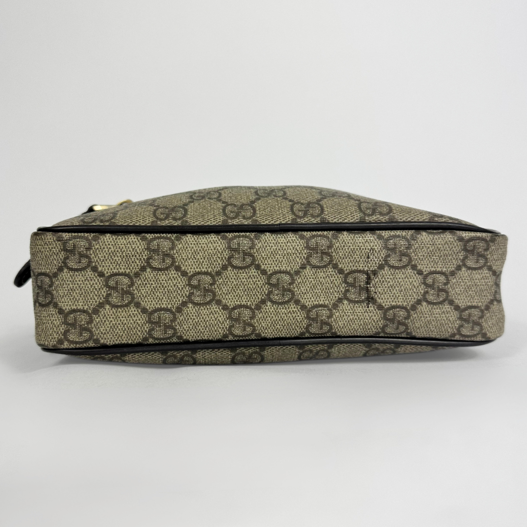 Gucci handbag with monogram pattern on a light gray background