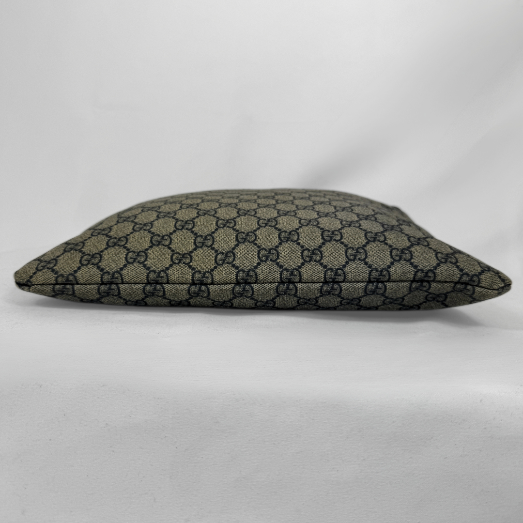 Gucci GG Supreme Web Flat Messenger bag in signature monogram canvas with green and red Web detailing and leather trims, displayed on a light grey background.