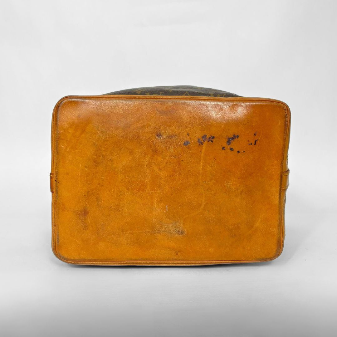 Brown leather suitcase with visible wear on a white background