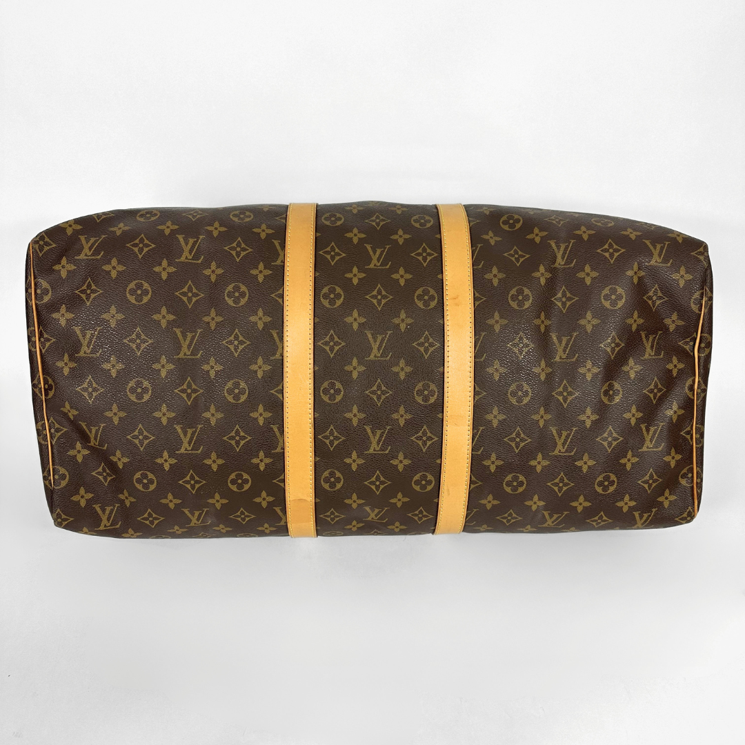 Louis Vuitton monogram duffel bag with tan handles on a white background