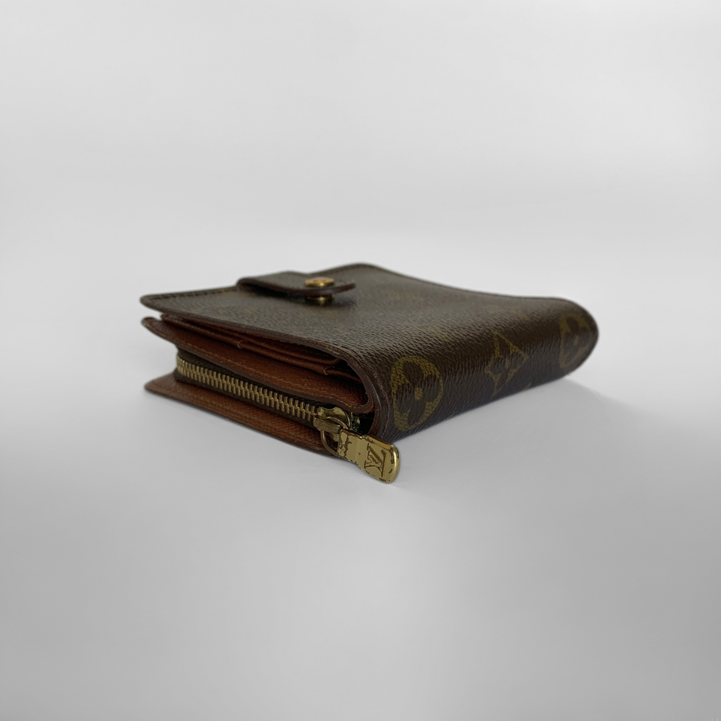 Brown wallet with gold zipper on a white background