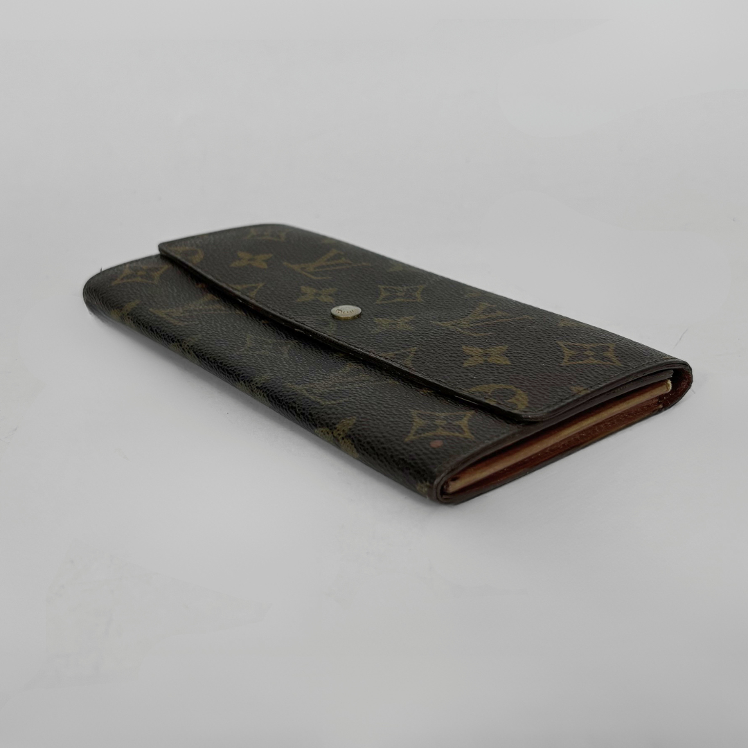 Louis Vuitton wallet with monogram pattern on a white background