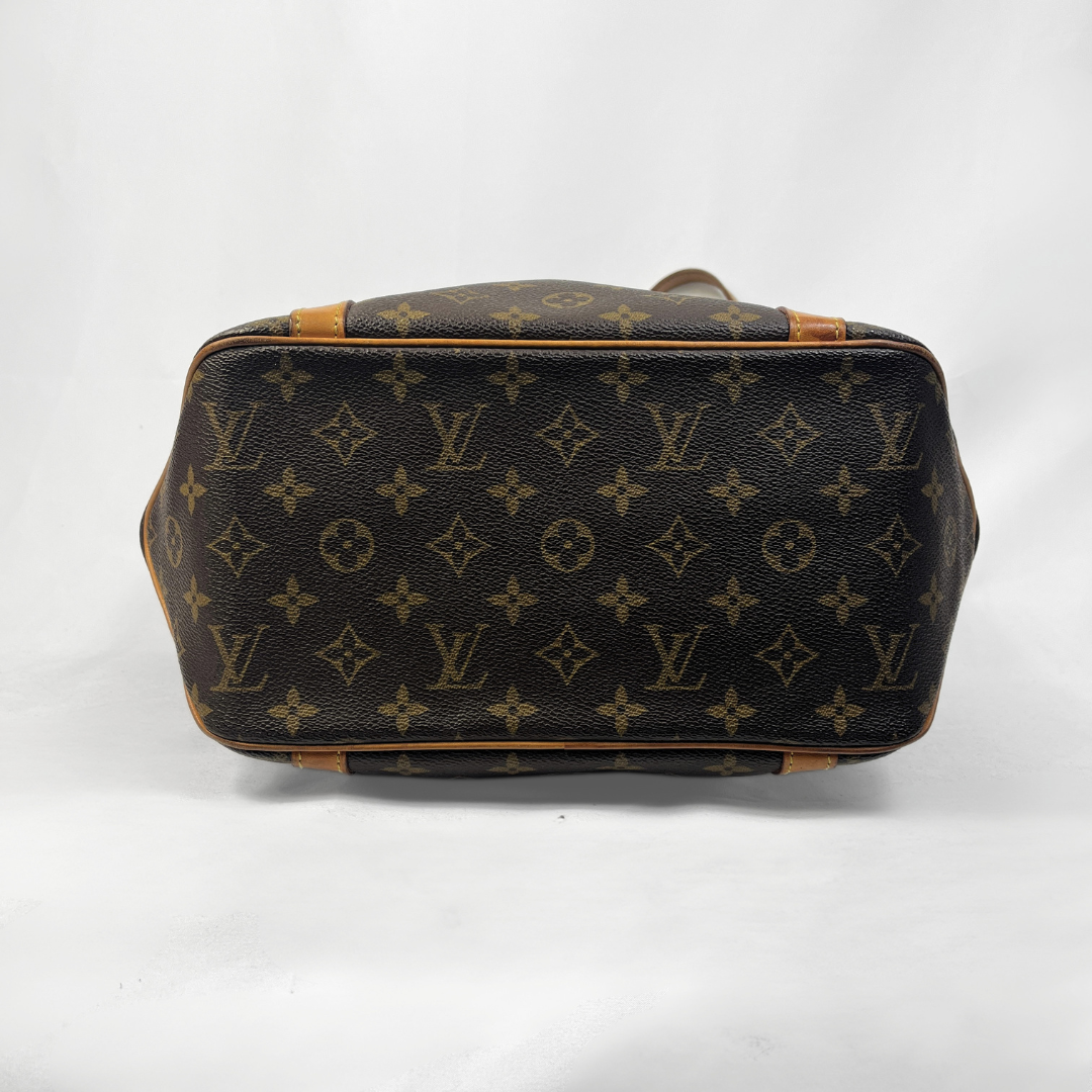 Louis Vuitton monogram canvas handbag shown from the bottom, featuring the classic dark brown and tan monogram pattern with tan leather trim on a white background.