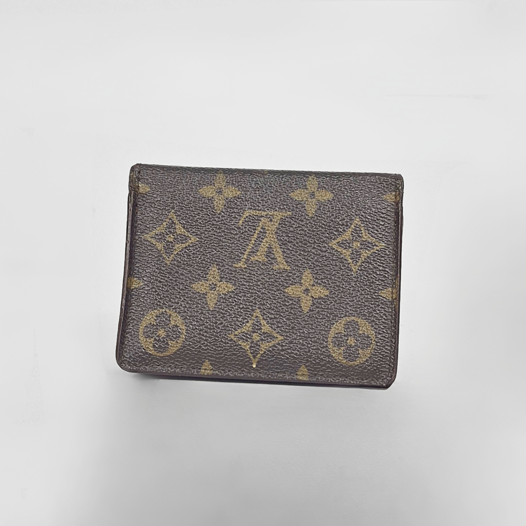 Louis Vuitton wallet with monogram pattern on a light gray background