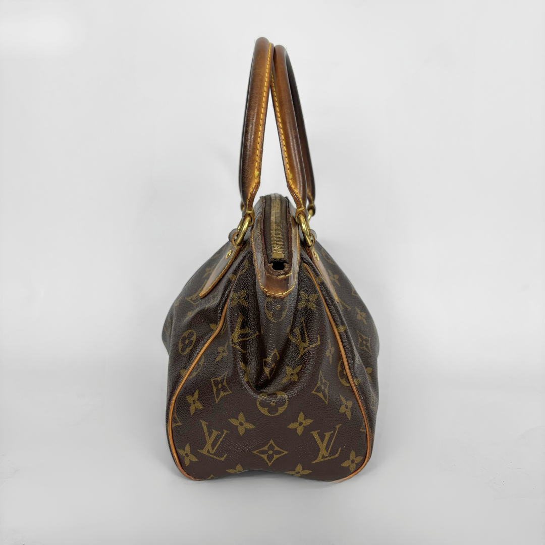 Braune Handtasche mit goldenen Akzenten auf weißem Hintergrund