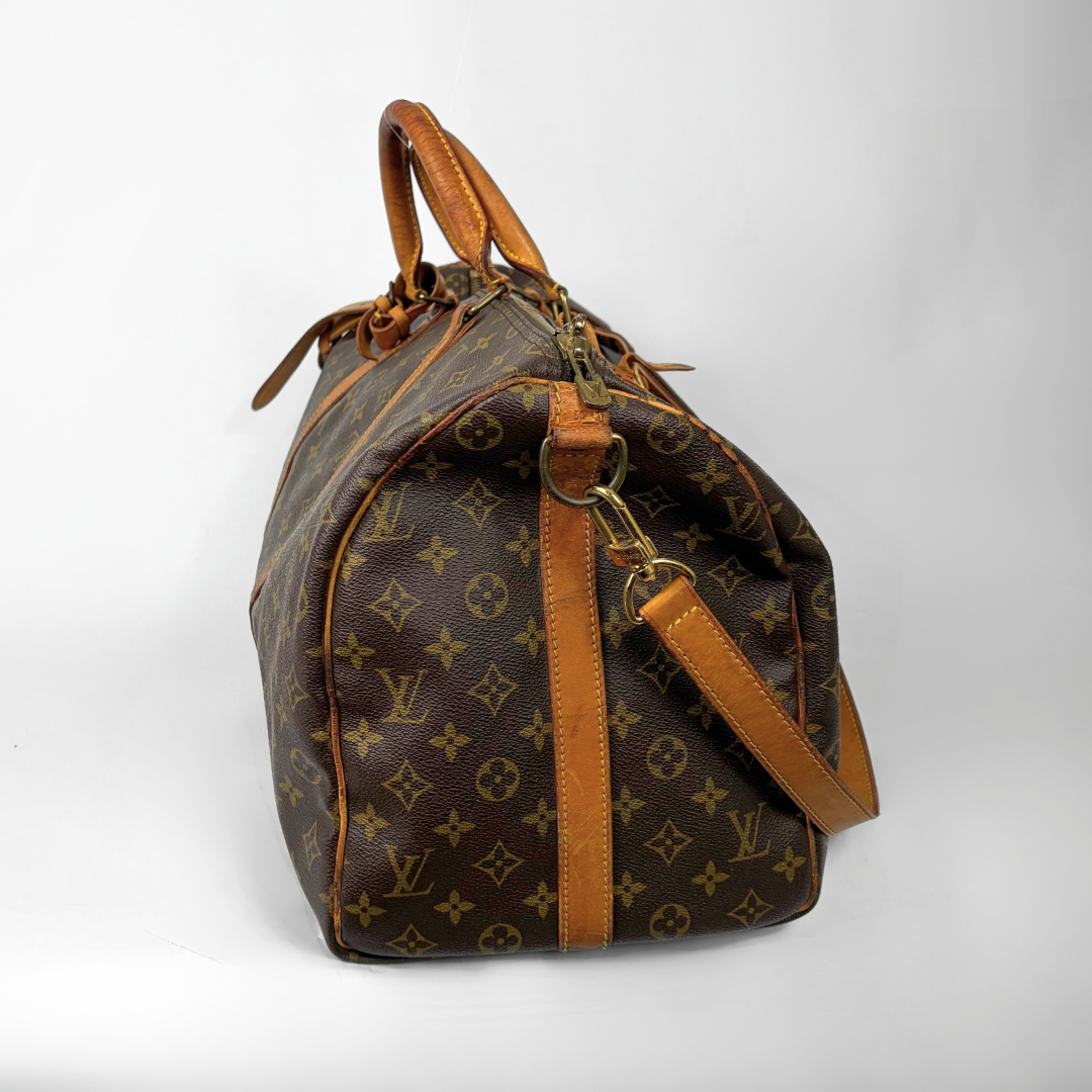 Reisetasche mit braunem Monogrammmuster, hellbraunen Ledergriffen und -riemen auf weißem Hintergrund
